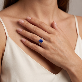 Vendôme-Ring mit synthetischem blauem Saphir im Smaragdschliff am Finger getragen, abgebildet in 18 Karat Weißgold — Maison Laveran Paris