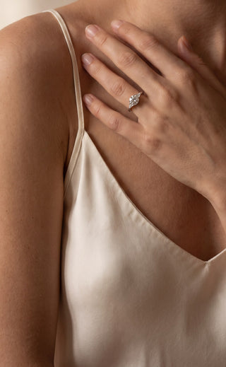 Bague de fiançailles Laveran en diamant de laboratoire portée à la main, posée sur la clavicule
